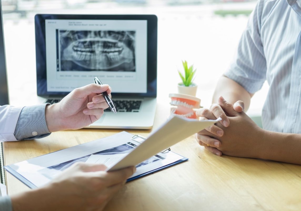 dental-hygienist-demonstrating-showing-dummy-jaw-chack-up-healing-teeth-patient-min